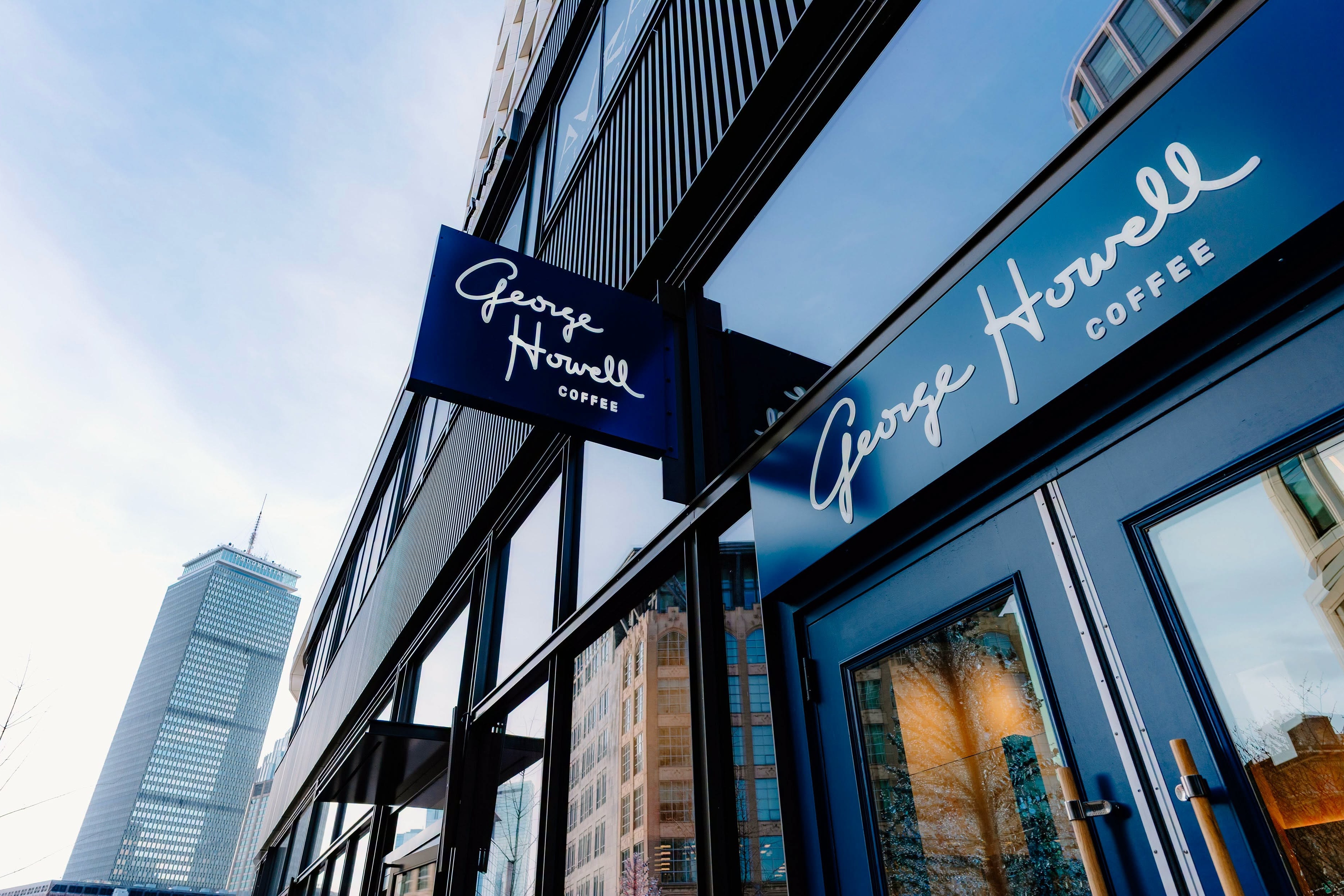 The George Howell Coffee sign on the Godfrey Hotel storefront, shot from below with the Prudential Tower behind it