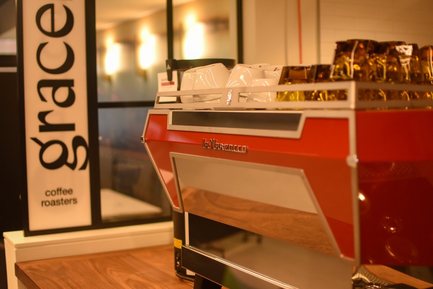 The red La Marzocco espresso machine and hanging Gracenote Coffee Roasters banner at the High Street Place counter