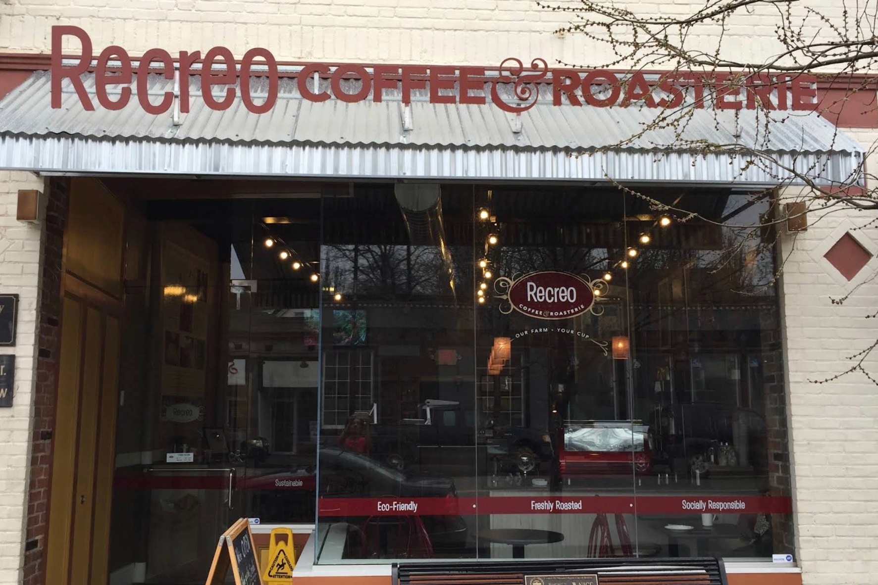 The Recreo Coffee & Roasterie storefront sign on Centre Street, with string lights visible through the window
