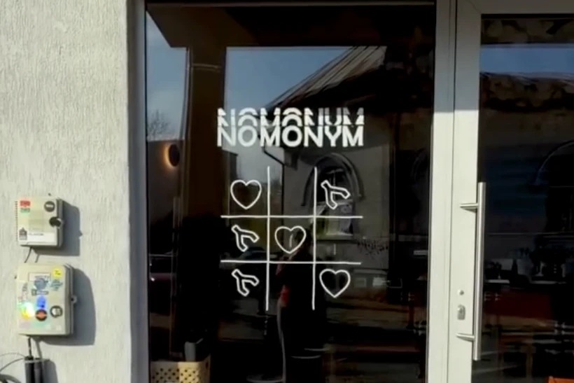 The NOMONYM window decal with a heart and paw print tic tac toe design at the shop's entrance