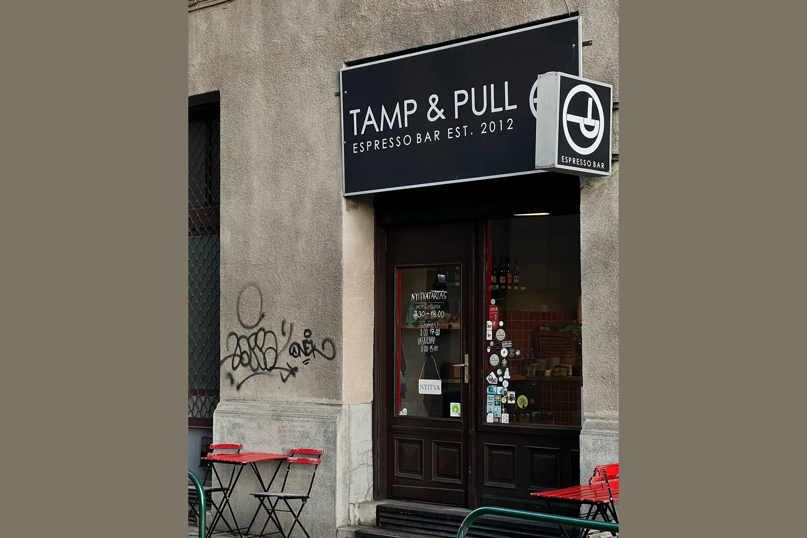 The Tamp & Pull sign above the Czuczor utca storefront, with the handwritten opening hours posted in the window