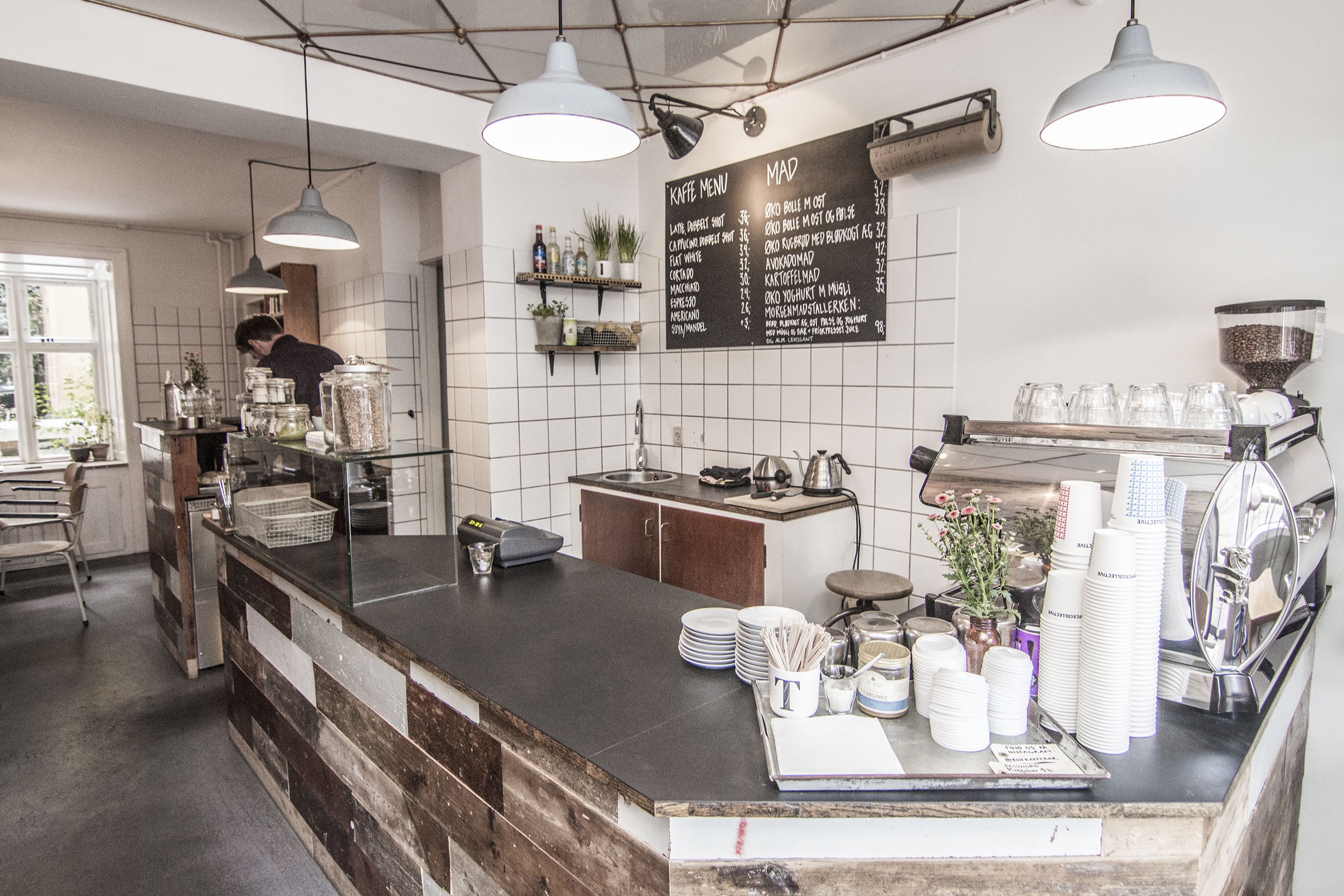 The reclaimed wood counter at Rist Kaffebar, with the chalkboard coffee menu, espresso machine, and stacked cups
