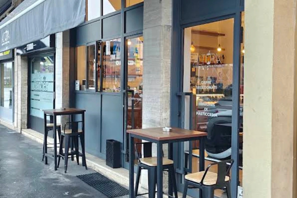 The Altura storefront on Via Lorenteggio, with the ALTURA sign in the window and two small outdoor tables set up out front