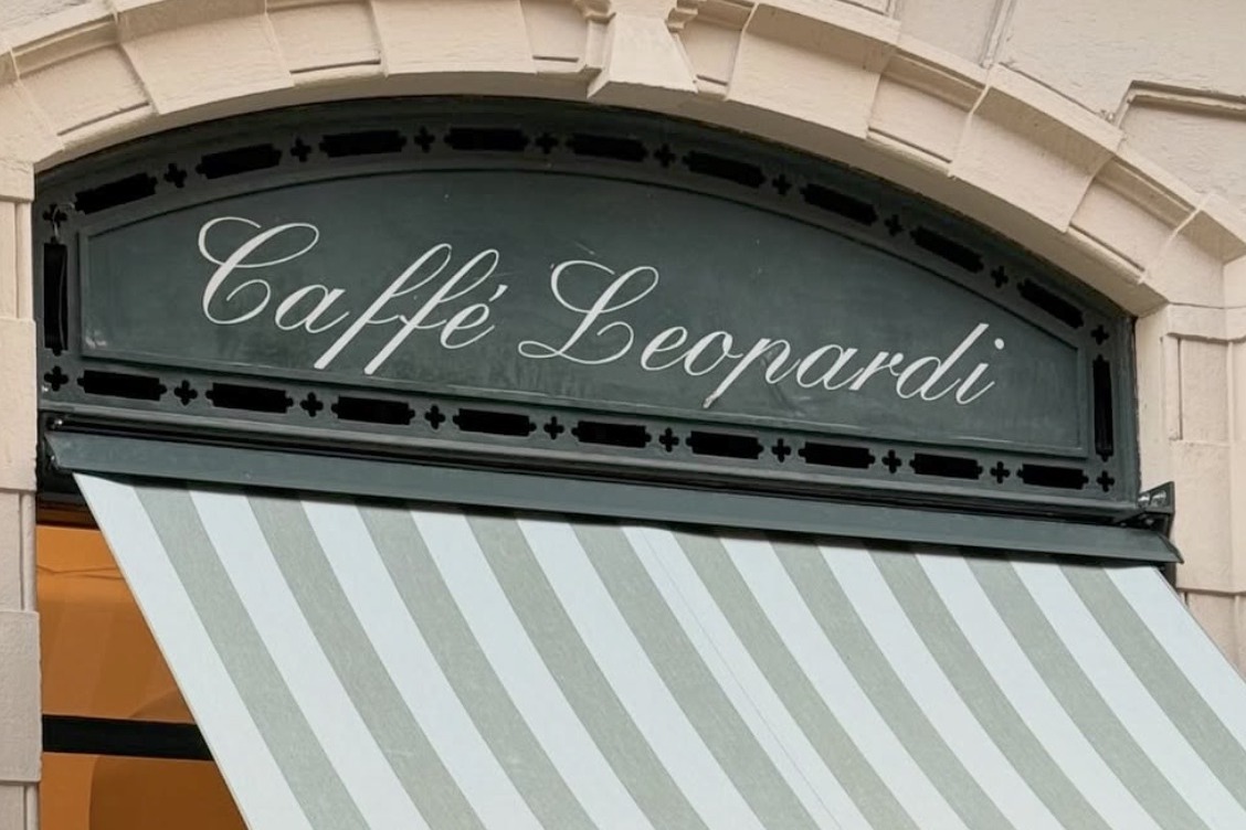 The elegant Caffè Leopardi sign in script lettering above a striped green and white awning
