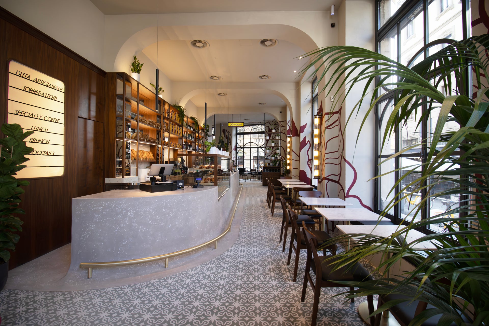 The curved terrazzo counter and mosaic floor inside Ditta Artigianale's Corso Magenta bar in Milan