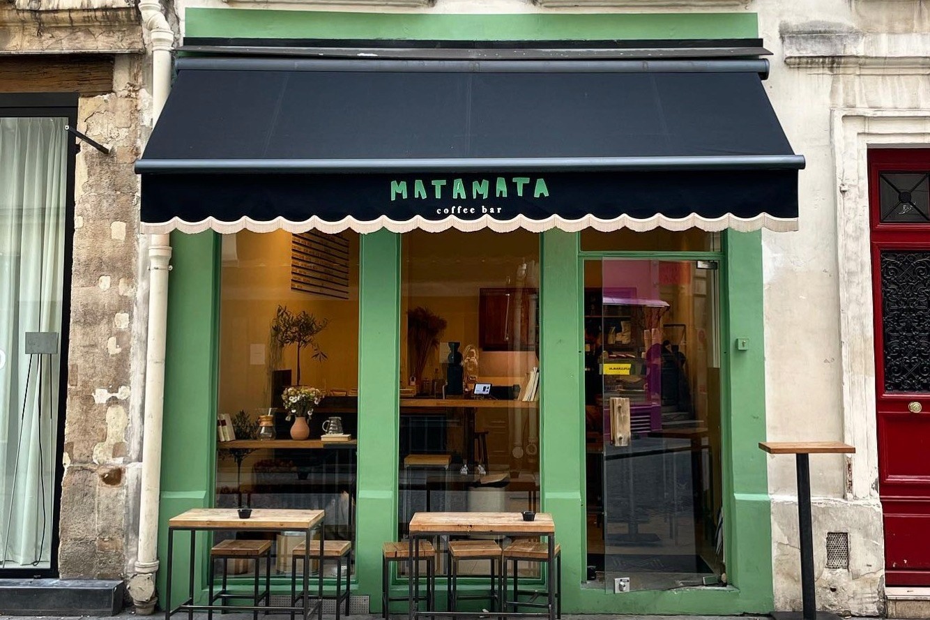 The green Matamata Coffee Bar storefront with its scalloped black awning and outdoor bar tables on Rue d'Argout
